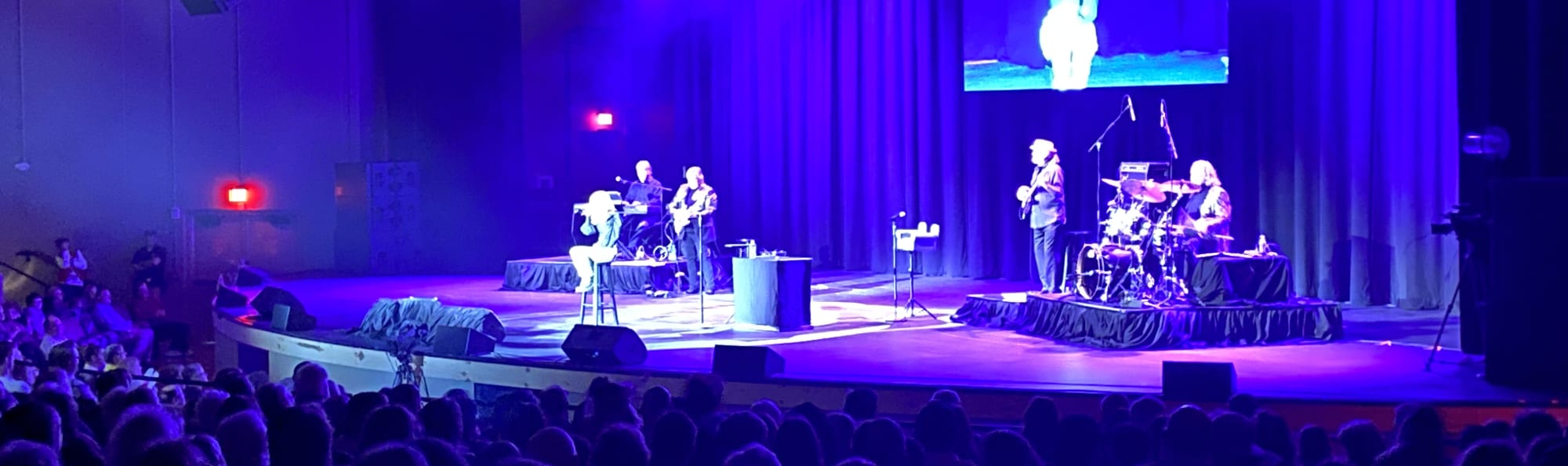 signer on stage in chair washed out by the lights Minneapolis